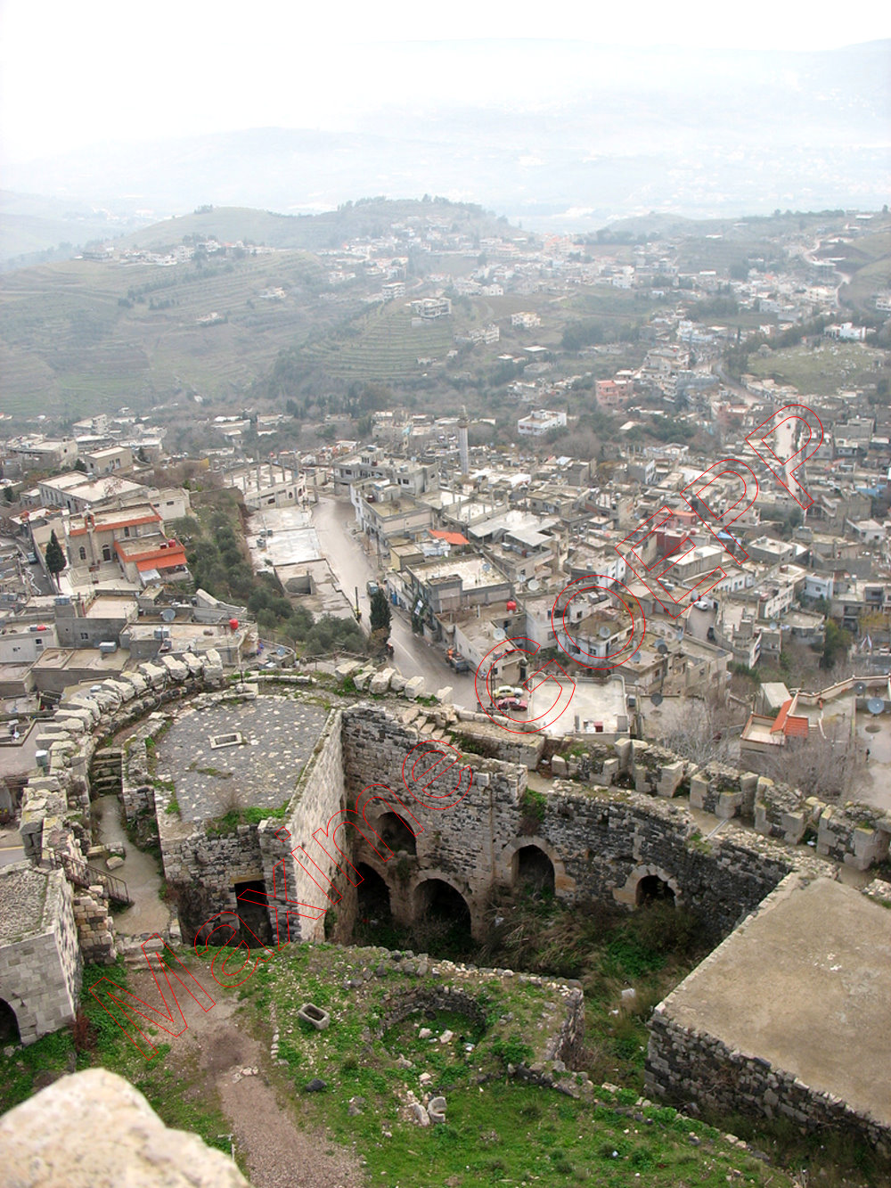 Secteur 7. Vue de dessus de l'angle nord-est de la grande terrasse, avec sur la gauche l'ouvrage de la poterne nord, la tour 32, puis la cour décaissée devant le tracé éventuel de l'enceinte primitive. La fosse arrondie correspond probablement à aménagement (four ?) d'une maison ottomane.